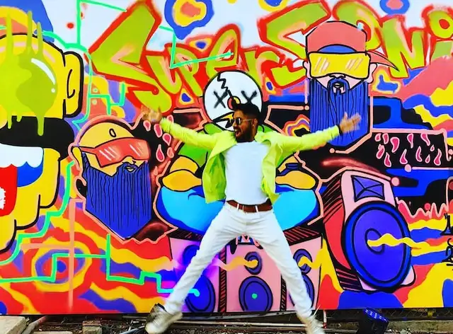 guy posing at graffiti wall art for the event vh1 supersonic 12
