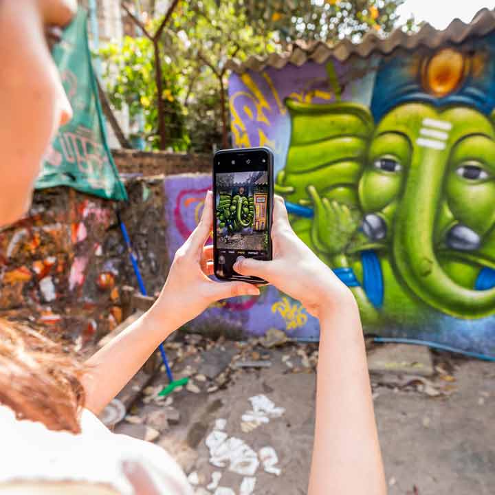 girl clicking ganesha mural at marol art village