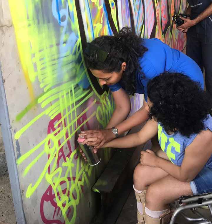 shirin shaikh guiding a participant at the graffiti workshop at ladies first street art community festival in Marol, Mumbai
