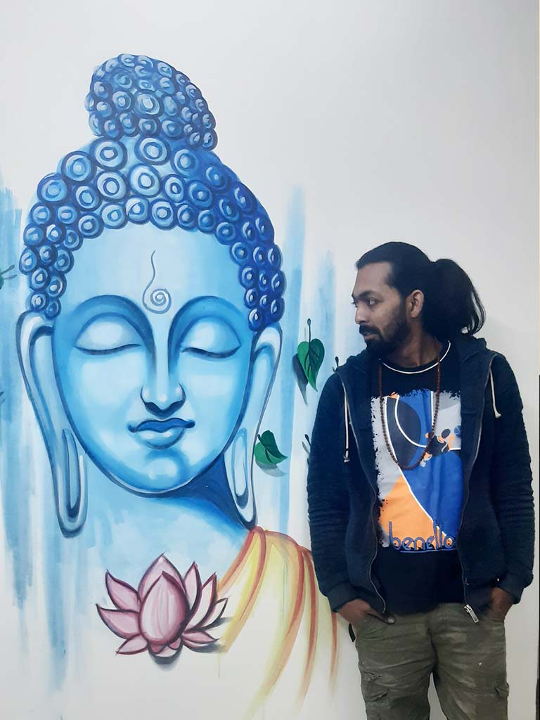 Artist Yogi Kumar with wall art of Buddha