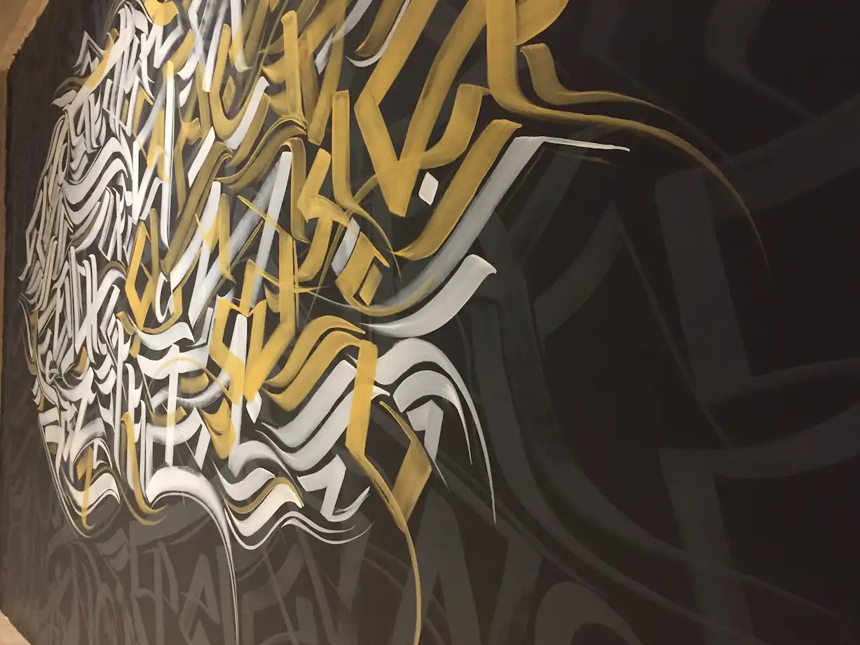 close look of white and gold stroke calligraffiti wall art at office advant 4